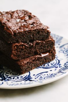 two chocolate brownies on a blue and white plate