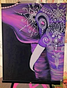 an elephant painted with purple and white paint