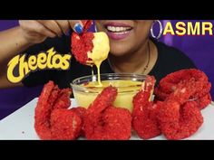 a woman is eating some food on a plate with sauce in front of her and the words cheetos asmr above it