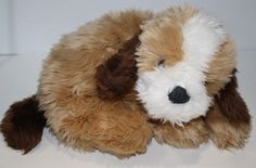 a brown and white stuffed dog laying down