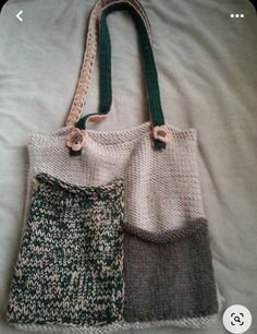 two purses sitting on top of a bed next to each other, one is green and the other is gray