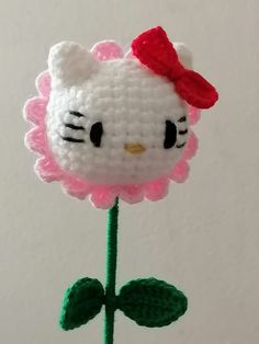 a crocheted hello kitty flower with a red bow on it's head