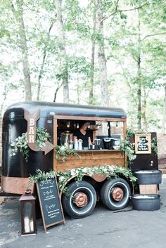 an old fashioned truck is decorated with greenery and chalkboard writing on the side