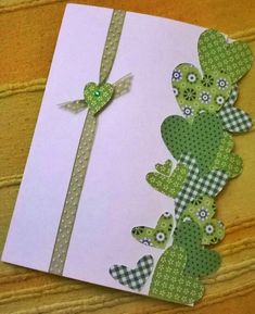 a card with green and white paper on it, decorated with flowers and hearts in the shape of cactuses