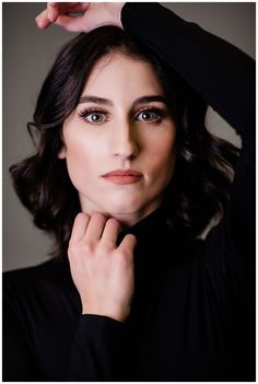 a woman is posing for a photo with her hands on her head