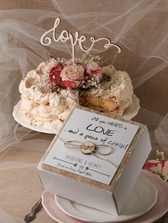 there is a wedding cake on the table with a card in front of it that says love