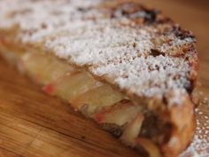 a piece of bread with powdered sugar on it sitting on a wooden table top