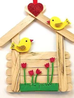 two little birds sitting on top of a wooden house with flowers in the window and a red heart hanging from the roof