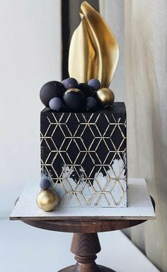 a black and gold cake sitting on top of a table