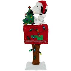 a snoopy christmas mailbox with a dog on top and a tree in the middle