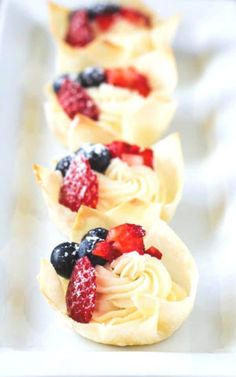 small desserts with fruit are lined up on a table