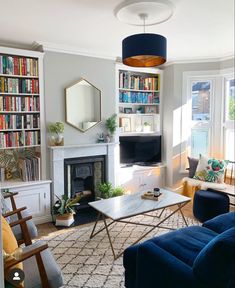 a living room filled with furniture and a fire place in front of a book shelf