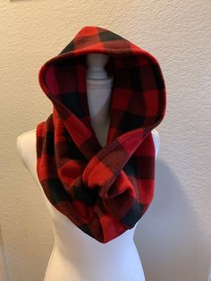 a white mannequin wearing a red and black plaid scarf