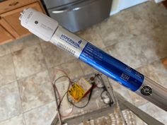 a blue and white toothbrush sitting on top of a kitchen floor