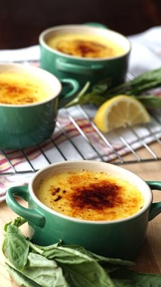 two green bowls filled with soup and garnished with herbs on a cooling rack