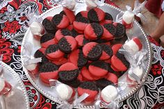 red and black heart shaped cookies are on a platter with white marshmallows