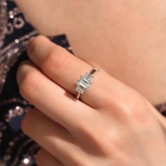 a woman's hand with a diamond ring on it