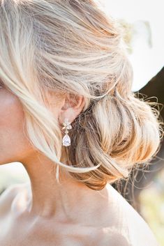 a woman with blonde hair and earrings on her head