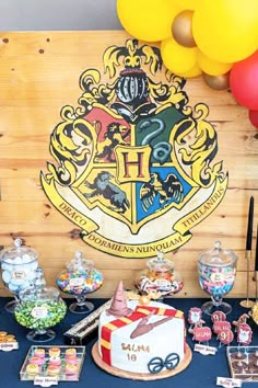 a harry potter birthday party with lots of food and balloons on the wall behind it