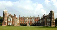 a large brick building sitting on top of a lush green field