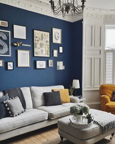 a living room with blue walls and pictures on the wall