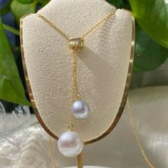 Elegant Asymmetric Dual Pearl Pendant – a harmonious blend of classic charm and contemporary design. Features two pearls: one pristine white and one sophisticated gray, each chosen for their luster and quality. The differing lengths of the pendants create a unique, eye-catching asymmetry, adding a modern twist to the timeless beauty of pearls. Pearl Type: Freshwater Edison Pearls Pearl Quality: AAA [Shape]: Perfect Round Pearl [Pearl Size]: 8-9mm & 12mm [Blemish]: Minimal to None [Luster]: Very Everyday Luxury White Pearl Drop Jewelry, Luxury White Gold Jewelry With Baroque Pearl, Luxury Silver Pearl Drop Necklace, Pearl White Akoya Pearl Drop Jewelry, Luxury White Gold Baroque Pearl Jewelry, Elegant Pear-shaped Pearl Pendant Jewelry, Luxury Silver Baroque Pearl Necklace, 14k Gold-filled Teardrop Pearl Pendant Necklace, Elegant Shell-shaped Pearl Drop Necklace