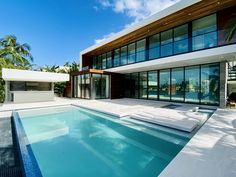 a large swimming pool in front of a modern house