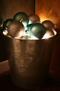 a bucket filled with christmas ornaments on top of a rug