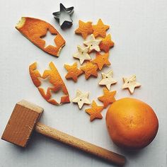 an orange, star shaped cookies and hammer on a white surface with stars scattered around it