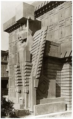 an old black and white photo of a building with sculptures on the front, side and top