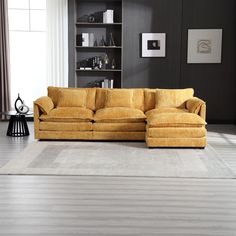 a yellow couch sitting on top of a wooden floor next to a book shelf filled with books