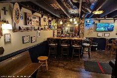 the inside of a restaurant with many tables and chairs in front of an empty bar