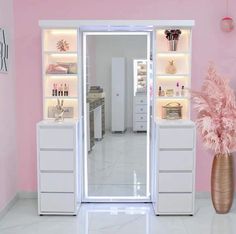 a pink and white room with an open door to another room, including a large vase filled with flowers