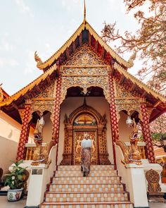 a man is walking up the stairs to a temple