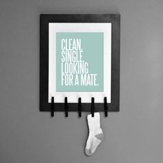 a black and white frame hanging on the wall with a pair of socks attached to it