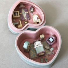 two pink heart shaped boxes filled with miniature furniture