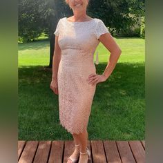 a woman in a dress standing on a wooden deck