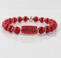 Clean lines and masculine elegance! This piece features by our custom designed Kappa Alpha Psi Greek letter center bead surrounded by natural Italian red coral beads, paired with silver plated beads. A beautiful combination, dressed up or dressed down, solo or stacked **All bracelets are made to order, so please follow the size guide to determine your correct size.** SIZE GUIDE Using a flexible measuring tape*, Measure just above (towards elbow) the wrist bone, to measure your actual wrist size. Adjustable Red Coral Beaded Bracelets As Gift, Spiritual Red Bracelets With Silver Beads, Letter Centers, Masculine Elegance, Kappa Alpha Psi Fraternity, Kappa Alpha Psi, Greek Letters, Sorority And Fraternity, Coral Beads