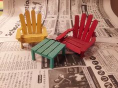 two miniature chairs sitting on top of a newspaper