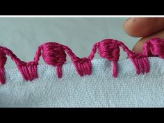 someone is stitching the word love on a piece of fabric with yarn in it