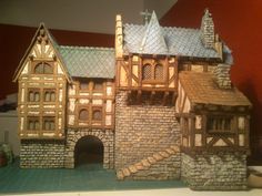 a model of a castle made out of wood and stone with a staircase leading up to it