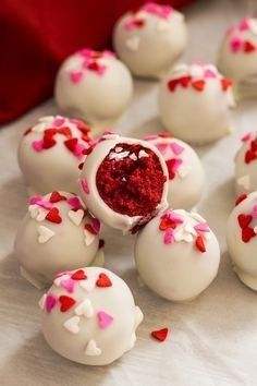 white chocolates with red and pink sprinkles are arranged on a table