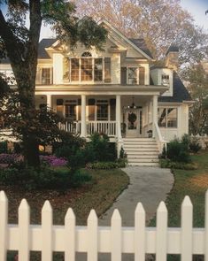 a house with white picket fence and trees