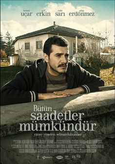 a movie poster with a man leaning on a wall in front of a house and looking at the camera