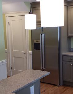 an empty kitchen with stainless steel appliances and wood flooring is pictured in this image