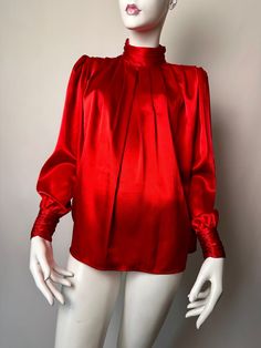 Vintage 80s 90s Tess Paris Milano Red High Neck Pleated Blouse. Beautiful Vintage Late 80s Early 90s Tess Paris Milano Blouse. This Lovely Classic Red Blouse Has A Draped High Neck with Ruching Detail On Each Side Complete With Three Opalescent Red Acrylic Buttons On The Back Of The Neck. Both The Front And Back Have Pretty Pleating Detail Classic Of That Era. This Blouse Also Had Lite Puff Sleeves With The Cuffs Mimicking The Design Of The Neck. A Bold Red Blouse That Adds The Perfect Pop Of Color. Pair It With A Skirt, Denim, Or With Your Favorite Blazer. Size 6. 100% Polyester. Made In Hong Kong. Preowned Vintage Condition. Shows Signs Of Lite To Mild Vintage Wear. Has A Few Faint Runs And Some Visible Threads. Overall, Great Vintage Condition. Retro Red Top For Party, Retro Red Party Tops, Red Retro Party Tops, Retro Red Party Top, Red Retro Party Top, Retro Red Formal Tops, Red Retro Formal Tops, Red Vintage Formal Top, Vintage Red Top For Formal Occasions