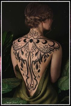 the back of a woman's body is covered in intricately designed tattoo designs