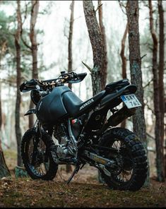 a dirt bike parked in the woods next to trees