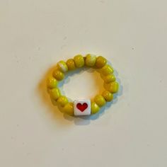 *Size: One Size *Color: Yellow *Product Detail: Good Quality Beads. Stretchy Elastic Band. 1 Red Heart Beaded Ring Yellow Beads. (Message For Customized Letters & Bead Color Preferences) *Condition: 100% Handmade. Brand New. *Note: Customizable Bracelet. Made To Order In 2-3 Days. Message Preference For Custom Colored Beads. Will Re-List Item Custom Ordered. *Note: Great Gifts For Party Bags. Message For Multiple Rings. Adjustable Yellow Jewelry With Heart Beads, Heart-shaped Letter Beads For Gifts, Yellow Beaded Bracelets With Heart Beads For Gifts, Yellow Heart Beads Jewelry For Valentine's Day, Yellow Jewelry With Heart Beads For Valentine's Day, Valentine's Day Yellow Jewelry With Heart Beads, Yellow Heart Beads Jewelry For Gift, Yellow Adjustable Jewelry For Valentine's Day, Cute Yellow Jewelry With Letter Beads