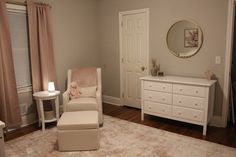 a baby's room with a chair, dresser and mirror